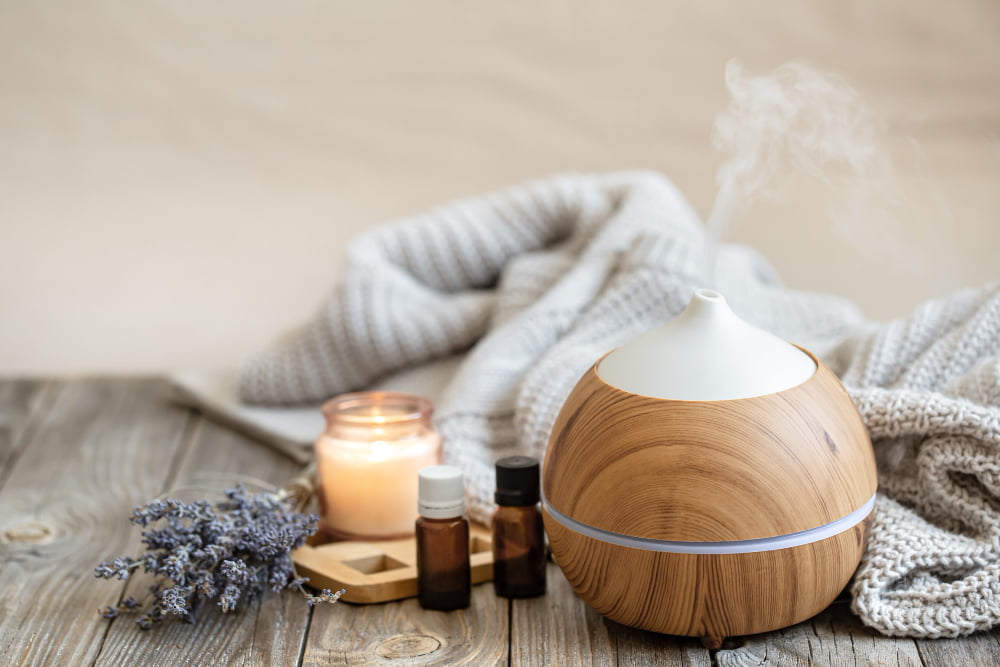modern aroma oil diffuser wood surface with knitted element candle lavender oil blurred background