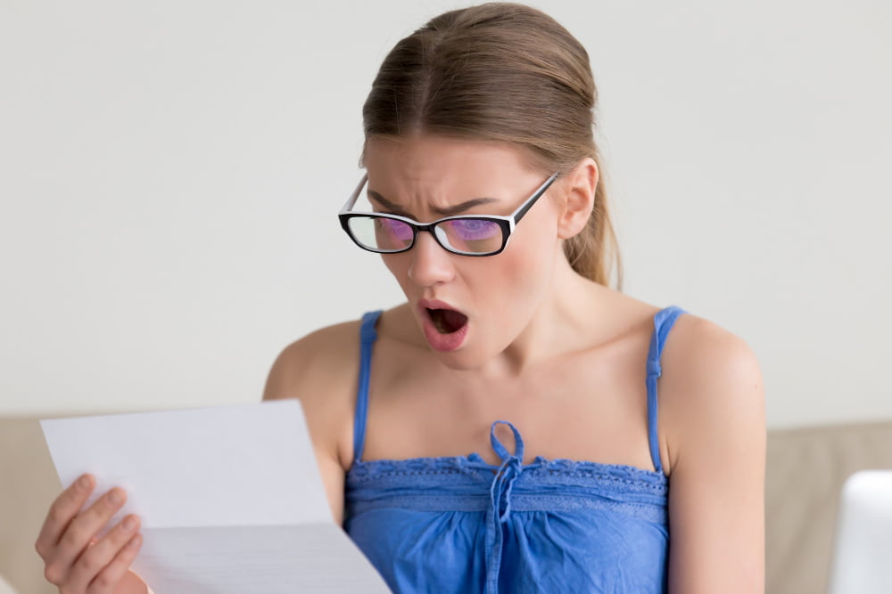 woman shocked when reading letter with bad news