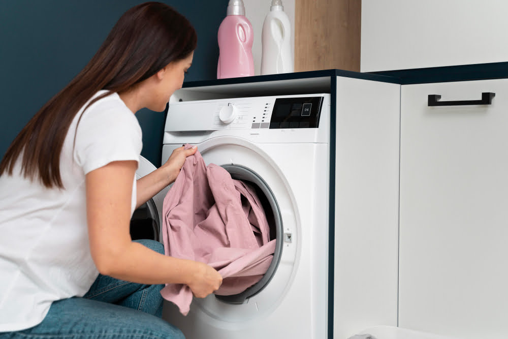woman taking clothes from washing machine